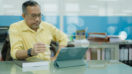 A senior adult businessman, smiling and engaged, attends classes and uses a tablet for learning, embracing technology to enhance his business acumen and stay updated in the modern business world.