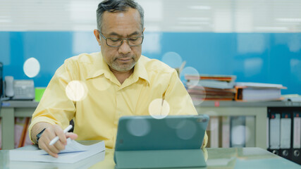 A senior adult takes classes on a tablet, actively learning through laptop and computer technology.