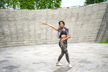 Joyful woman dancing cuban salsa alone in a park