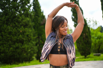 Cuban woman smiling raising arms dancing music outdoors