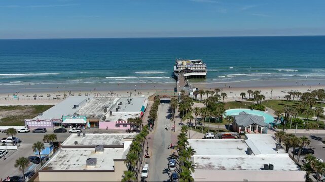 Daytona Beach Aerial Fly East from streets to over pier ocean