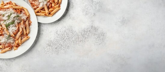 Two plates penne pasta white textured background is Top view of