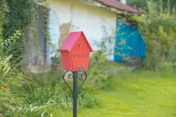 a red mailbox/postbox shaped like a house