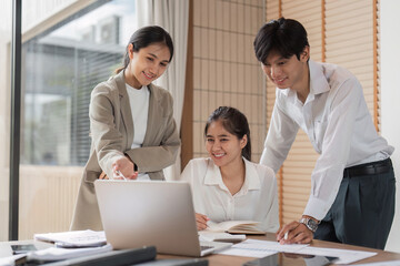 Business Team Collaborating on Project in Modern Office Setting with Laptops and Documents