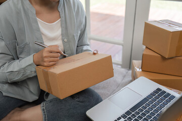 Young Woman Managing Online Small Business, Preparing Packages for Shipping with Laptop