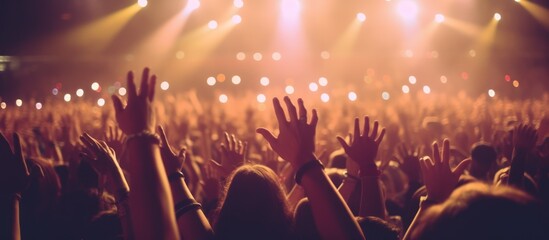 Concert Crowd with Raised Hands Under Stage Lights