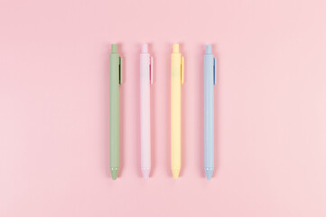 Top view of colorful pens on pink background. School, office wallpaper. Flat lay, copy space.