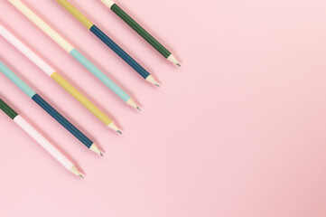 Top view of colorful pencils on pink background. School, office, art wallpaper. Flat lay, copy space.