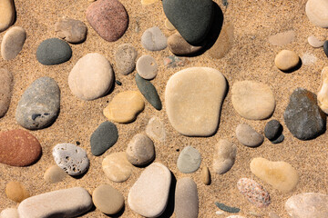 Stone, all partially buried and neatly arranged by the Lake Michigan waves along the beach at...