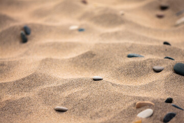 Stones rest peacefully among the indentations of the beach sand at Kohler-Andrae State Park,...