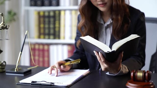 A female attorney/lawyer is diligently working at her desk in the office.