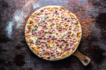 Funghi pizza topping with wurstel served in wooden board isolated on dark background top view of italian fastfood