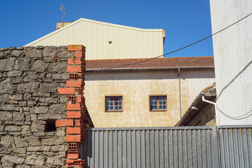 Muro de piedra y puerta de metal en conjunto de edificios viejos