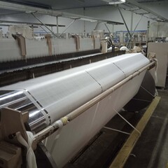 Modern Carpet weaving factory. Carpet making machine needle. Yarn bobbins attached to a carpet weaving machine. Inside Interior of a Fabric Weaving Factory.