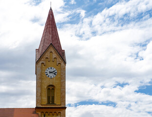 A clock tower with a red roof and a clock on the facade