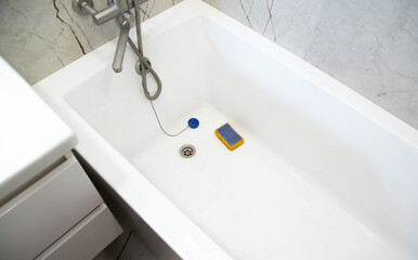 Washing and cleaning an acrylic bathtub from limescale and dirt. Add whiteness and shine to the plumbing fixtures. Cleaning services. Copy space for text, antimicrobial