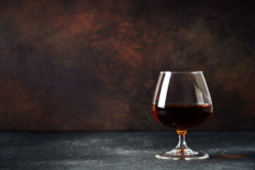 Cognac at dark background. Strong alcohol drink with copy space.