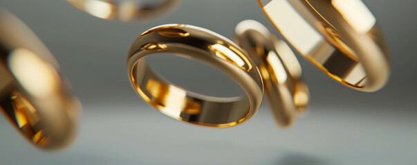 Gold rings floating in front of a gray background, highlighting their elegance and timelessness.