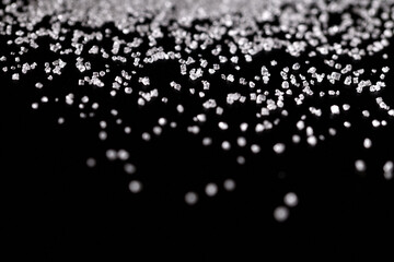 Extreme macro photography of white crystal sugar isolated on black background