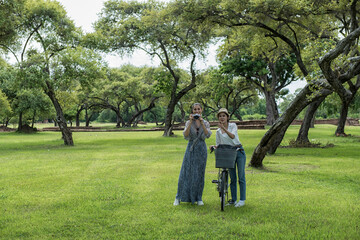 Fototapeta premium Woman travel in historical temple with bicycle. Tourist Travel taking a photo temple in Ayutthaya Woman travel in historical temple with bicycle. Tourist Travel taking a photo temple in Ayutthaya. 