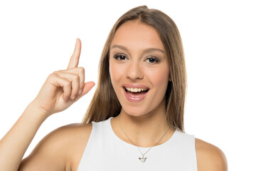 Young woman happy and pointing up isolated on white background