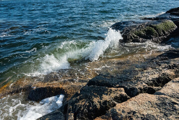 Sea waves breaking on the rocky shore of the Canada Sea coast.
