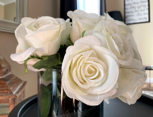 Racimo de rosas blancas en jarrón en una sala interior. 