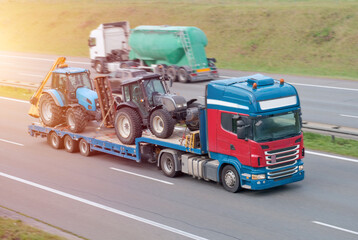 Naklejka premium Semi-Truck Transporting Tractors on Flatbed Trailer