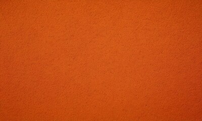 Fototapeta premium close-up of a textured orange surface, possibly a wall or a piece of paper.