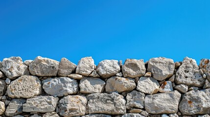 Stone wall with detailed, natural textures and a clear blue sky, ideal for background or texture reference