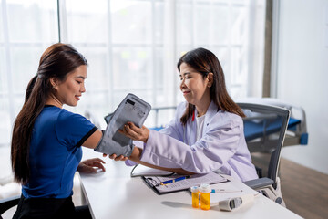 A woman is having her blood pressure taken by a doctor