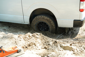 The wheel of a van stuck in the sand, Stuck tires, Method of service car bogged into lava sandy by...
