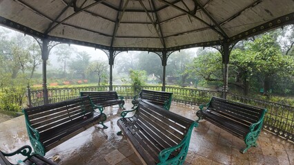  Gazebo in a public park with chairs underneath, providing a shaded area for relaxation and social gatherings