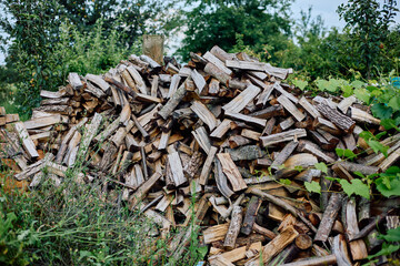 A pile of chopped firewood in the garden in the country