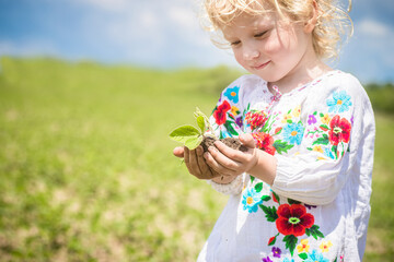 Celebrating Ukrainian Independence Day With a Young Child Planting Seeds in a Lush Green Field