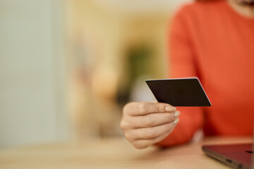 Close-up photo of a female hand holding a credit card.