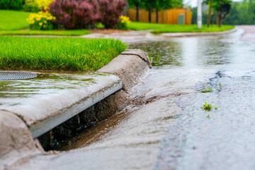 Stormwater flowing into street intake drain after a rainstorm