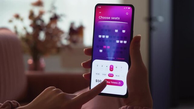 Buying cinema tickets online. Choosing seats in movie theater and buying tickets using app for mobile phone. Fictional Interface.