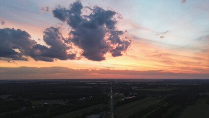 Colorful sunset with heavy clouds over fields before rain