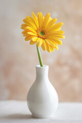 A single yellow daisy in a white vase against a neutral background, epitomizing simplicity and elegance with space for copy.