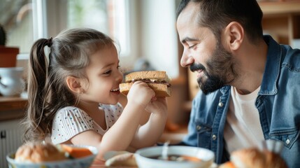 A man and a little girl are eating sandwiches together