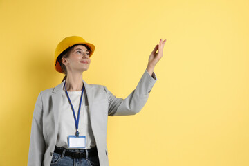 Engineer in hard hat on yellow background, space for text