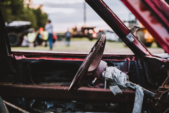 Selective focus on the interior steering column and wheel on a modified car for a demolition derby