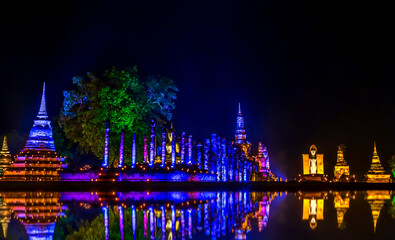 Colorful lighting and reflecting on ruined ancient historic landmark in world heritage Sukhothai,...