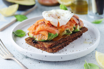 A rye bread sandwich with avocado and salmon