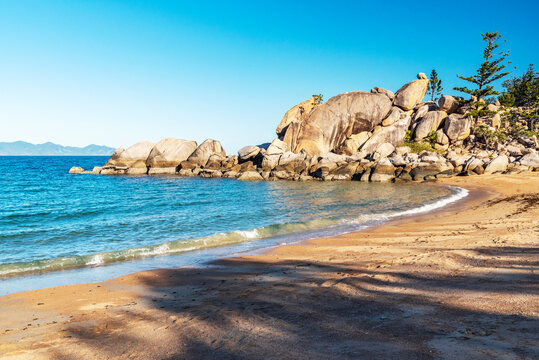 Picturesque golden sandy Arthur Beach with granite boulders and turquoise water on Magnetic Island, Queensland, Australia. The island is a holiday destination 8 km offshore of Townsville.