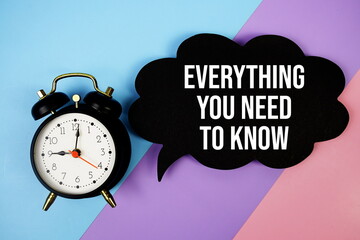 Everything You Need To Know text on speech bubble with alarm clock top view on blue, purple and pink geometric background