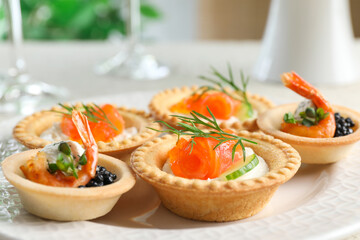 Delicious canapes with shrimps, salmon and caviar on table, closeup