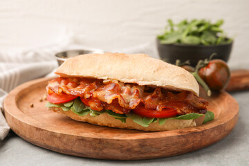 Tasty sandwich with bacon on grey table, closeup