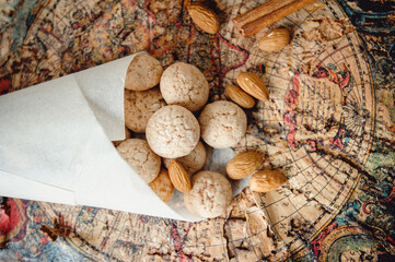 Almond cookies amaretti. Almonds,  and a cinnamon stick lie on an old map